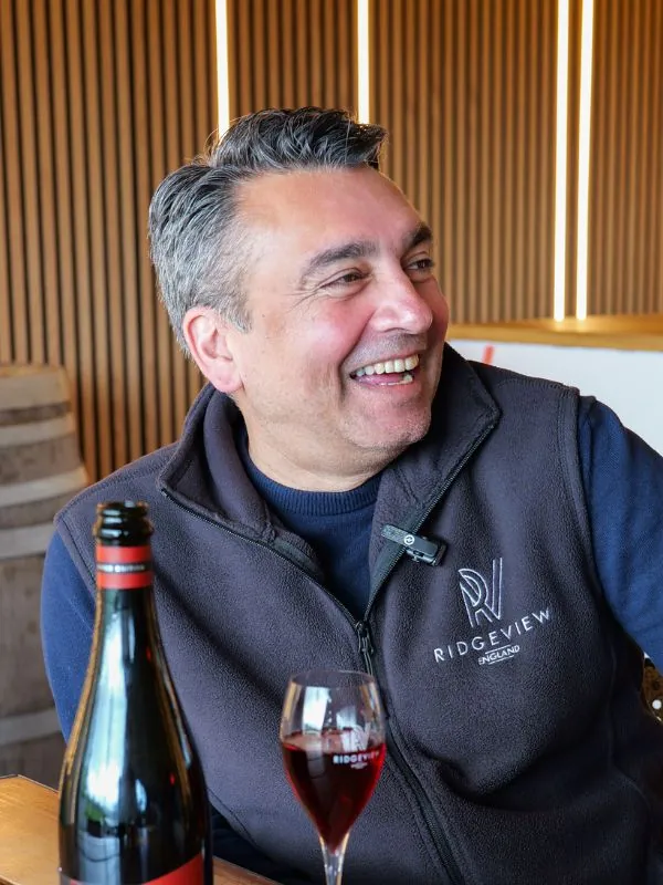 Simon Roberts, Ridgeview Head Winemaker smiling with Red Reserve