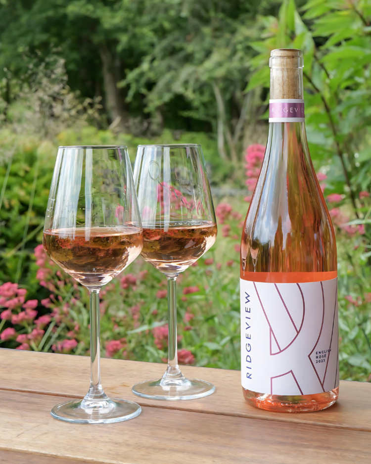 Ridgeview English Rosé Wine bottle with 2 glasses amongst flowers in the garden at our restaurant