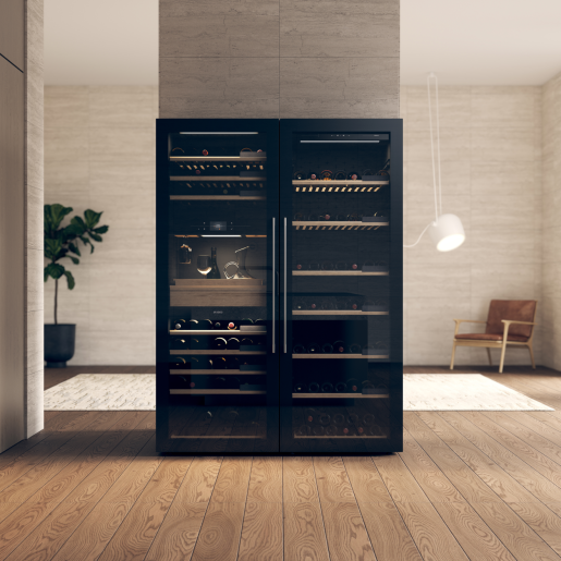 A double fronted black wine climate cabinet with wine bottles inside, in a home with wooden floors and a scandi home aesthetic.