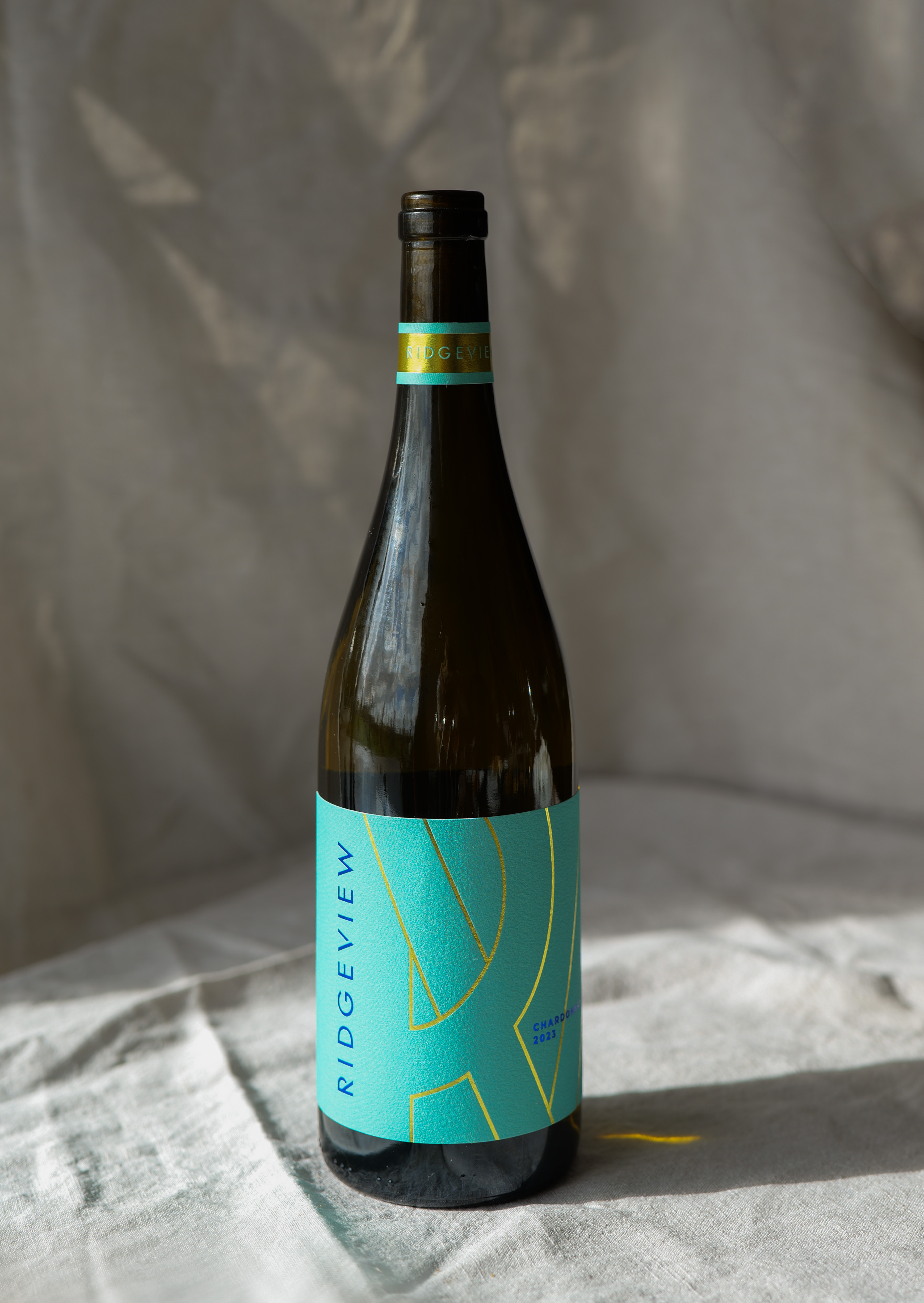 A bottle with a green label with a linen background and shadows