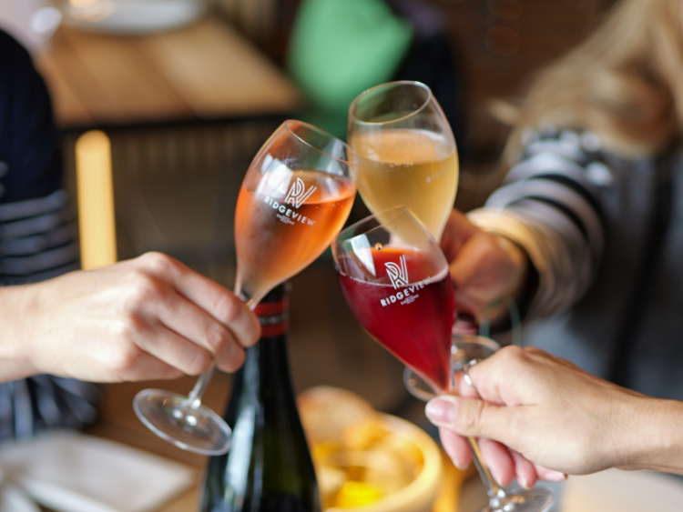 3 glasses in hands, cheersing (each glass has white, red and rosé)